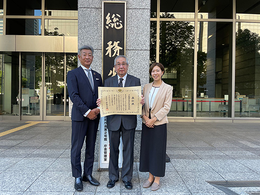 写真：【令和6年 防災功労者内閣総理大臣表彰　関係者一同】9月13日（金）総務省前にて撮影
	（左より、パナソニック　ホームズ株式会社　廣田 靖行、戸越銀座商店街連合会　山村 俊雄、株式会社HITOTOWA 鳥山 あゆ美）