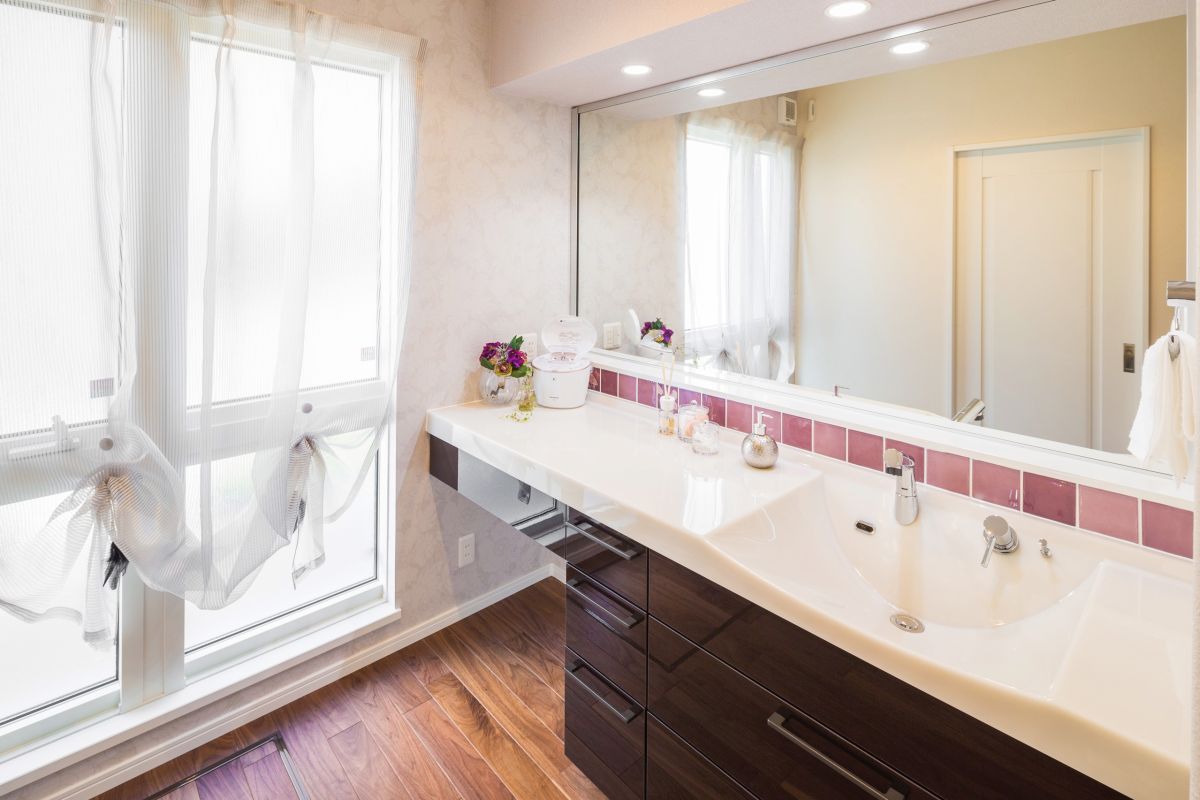 鏡の下のピンクのタイルがかわいいワンポイントアクセントになった1階洗面室。2人並んでの朝の身支度も余裕の広さです。